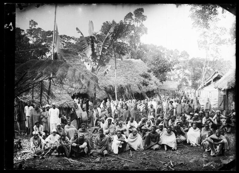 Rassemblement d’une population d’origine servile, des travailleurs « engagés », le 1er janvier à Nyumɓadjuu, une plantation appartenant au colon Léon Humblot. Photographie prise entre 1890 et 1896. © ANOM