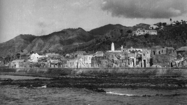 Vue de la façade maritime de la ville de Mtsamɗu, à Ndzuani, dominée en hauteur par sa citadelle, photographiée en 1952. © Pierre Coudert/ECPAD